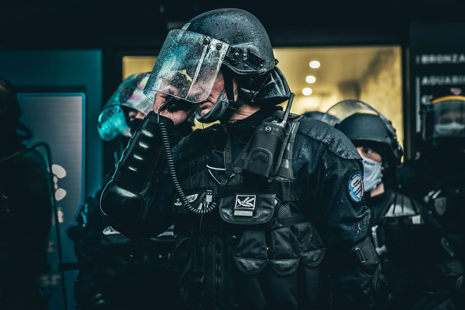 Policier d'une unité de maintien de l'ordre en tenue de protection, casque et masque, lors d'une intervention nocturne